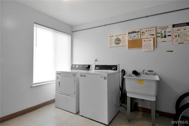 shared laundry area with baseboards, a sink, and washing machine and clothes dryer