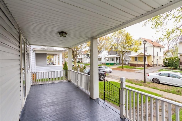 wooden terrace with covered porch and a residential view