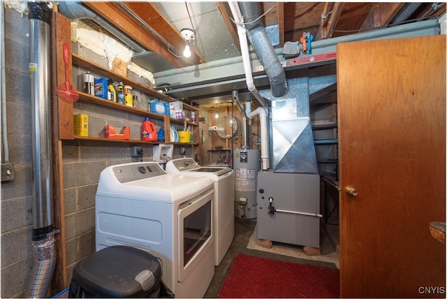 washroom featuring concrete block wall, gas water heater, heating unit, washer and dryer, and laundry area