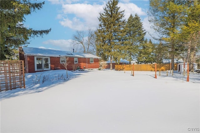 snow covered property featuring fence