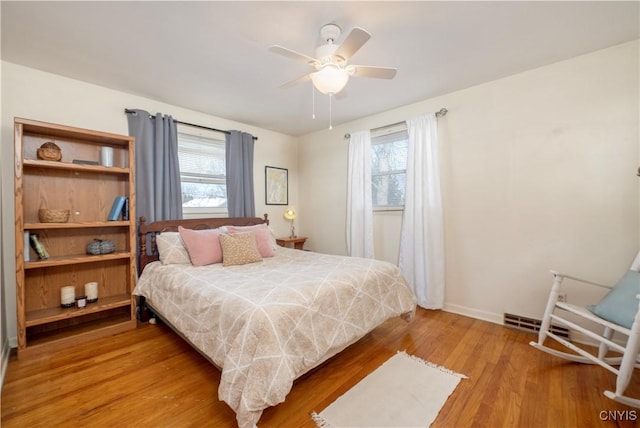 bedroom featuring wood finished floors, a ceiling fan, and baseboards