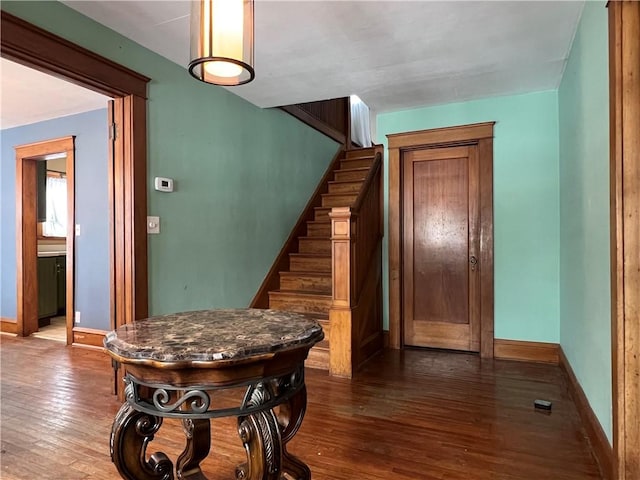 staircase with wood finished floors and baseboards