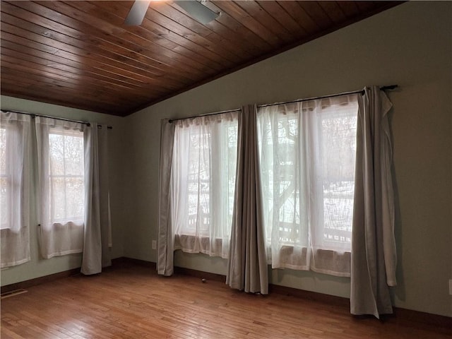 empty room with vaulted ceiling, ceiling fan, light wood finished floors, and wood ceiling