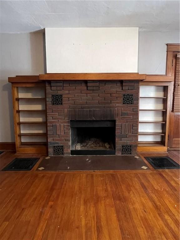 room details with a fireplace, visible vents, and wood finished floors