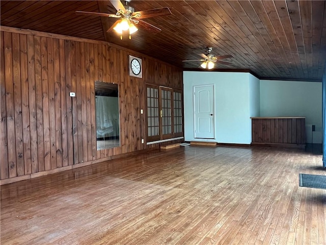 interior space with wood walls, wood ceiling, ceiling fan, and wood finished floors