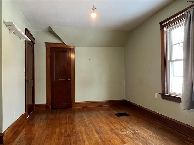 bonus room with lofted ceiling, visible vents, baseboards, and wood finished floors