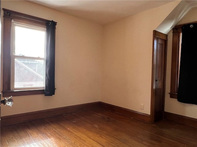 unfurnished room with dark wood-style flooring and baseboards