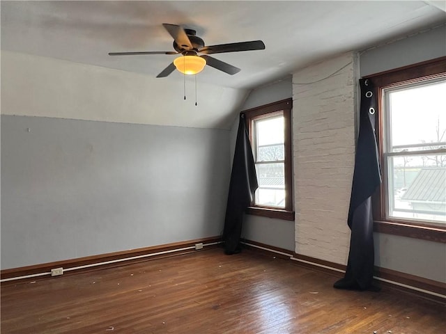 spare room with dark wood-style floors, lofted ceiling, ceiling fan, and baseboards