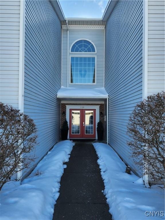 snow covered property entrance with french doors