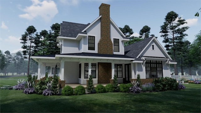 view of front facade featuring a porch, a front yard, brick siding, and a chimney