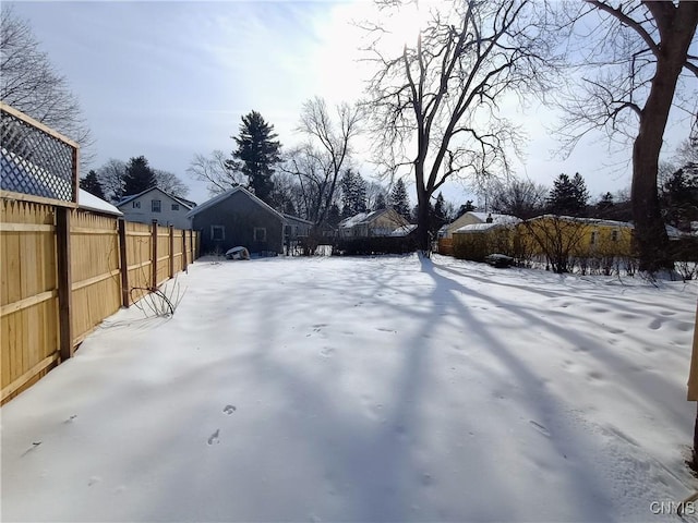 snowy yard featuring fence and a residential view