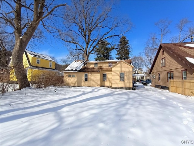 view of snow covered back of property