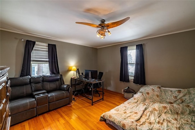 living room featuring a ceiling fan, crown molding, and light wood finished floors