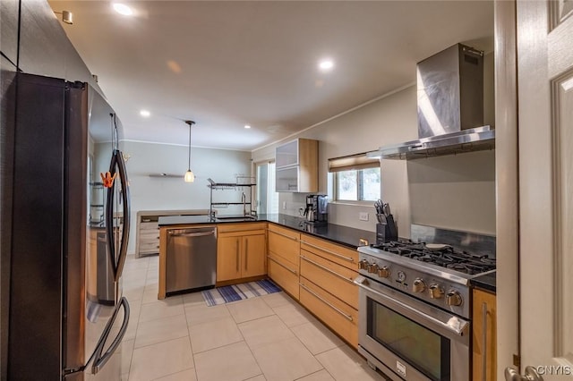 kitchen featuring a peninsula, appliances with stainless steel finishes, dark countertops, and wall chimney range hood