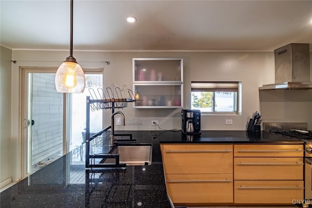 kitchen featuring wall chimney exhaust hood, ornamental molding, hanging light fixtures, open shelves, and a sink