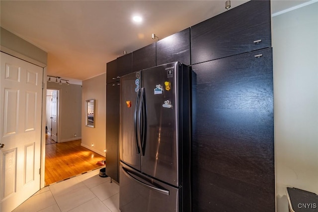 kitchen featuring baseboards, modern cabinets, light tile patterned flooring, and freestanding refrigerator