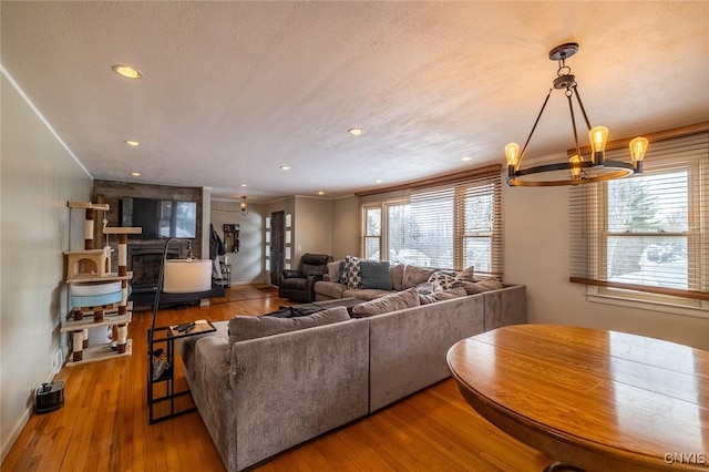 living room featuring a textured ceiling, ornamental molding, and wood finished floors