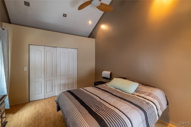 bedroom featuring high vaulted ceiling, light wood-type flooring, a closet, and ceiling fan