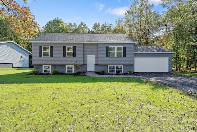 split foyer home with an attached garage, a front yard, and gravel driveway