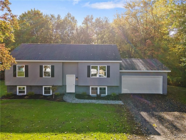 bi-level home featuring a garage, driveway, roof with shingles, and a front yard