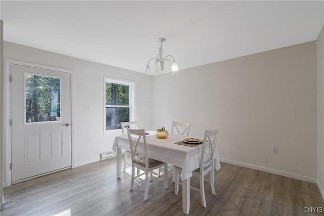 dining room with visible vents, a notable chandelier, baseboards, and wood finished floors