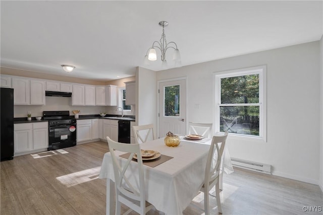 dining space featuring a baseboard radiator, an inviting chandelier, baseboards, and light wood finished floors