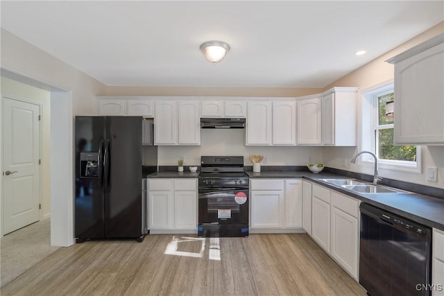 kitchen with under cabinet range hood, a sink, white cabinetry, black appliances, and dark countertops