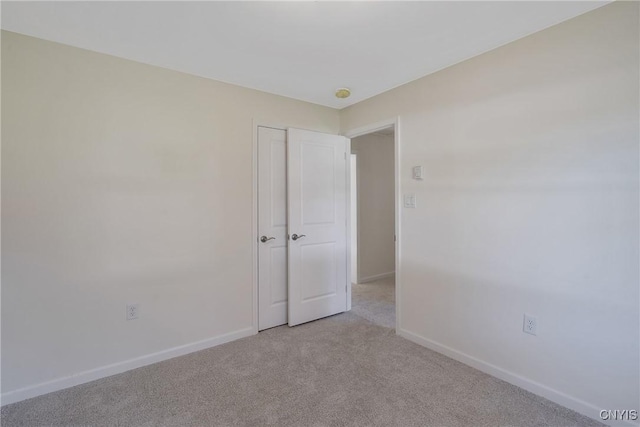 unfurnished room with light colored carpet and baseboards