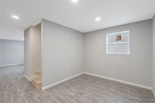 spare room with baseboards, recessed lighting, and light wood-style floors