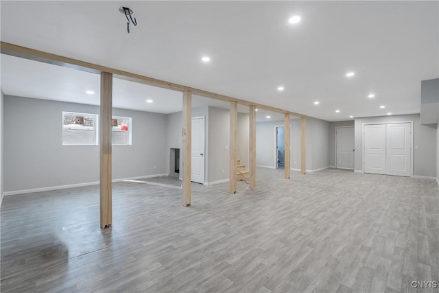 below grade area featuring baseboards, light wood-type flooring, and recessed lighting