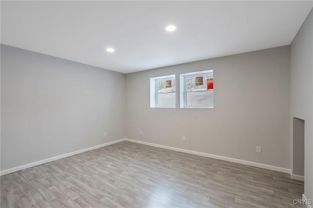 spare room featuring baseboards, wood finished floors, and recessed lighting