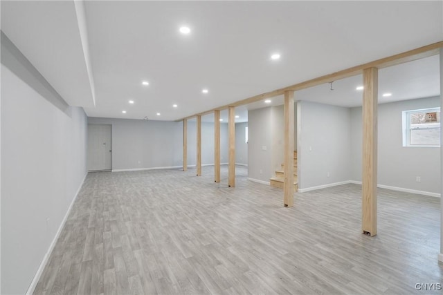 below grade area with light wood finished floors, baseboards, and recessed lighting