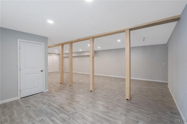 finished basement with light wood-type flooring, baseboards, and recessed lighting