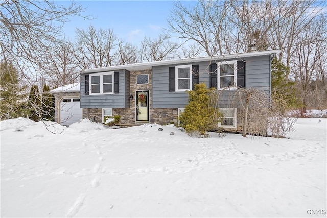 bi-level home with a garage and stone siding