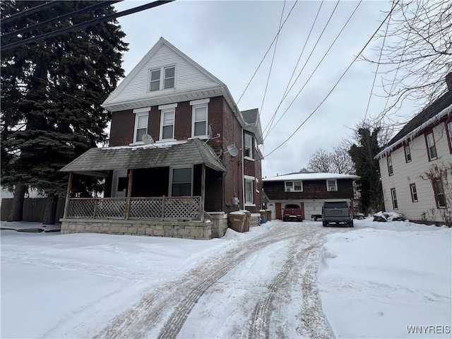 view of front of property with a garage, a porch, and brick siding