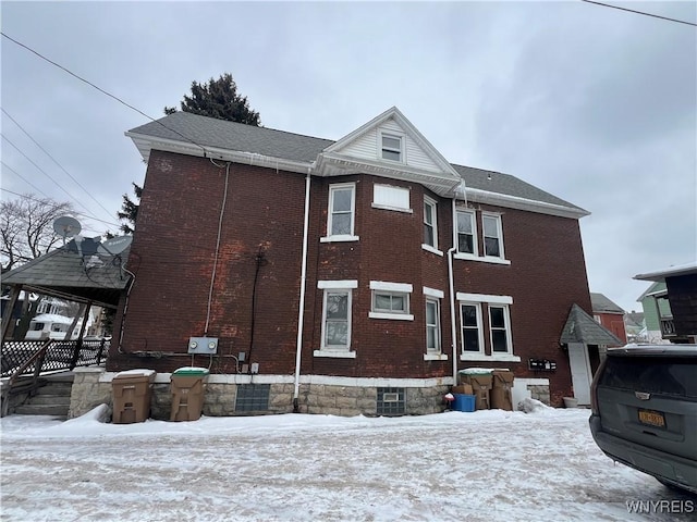 view of snow covered exterior featuring brick siding