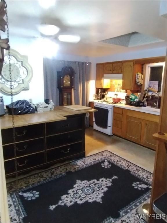 kitchen with brown cabinetry, light countertops, and gas range gas stove