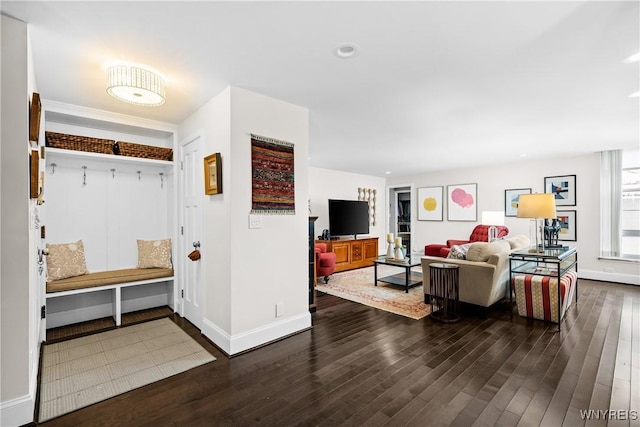 mudroom with dark wood-style floors and baseboards