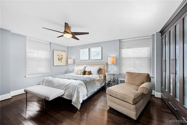 bedroom featuring dark wood-type flooring, multiple windows, and baseboards