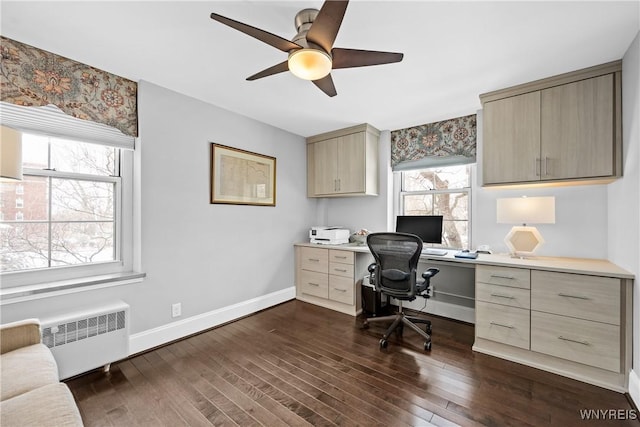 office area featuring a ceiling fan, baseboards, dark wood finished floors, and radiator heating unit