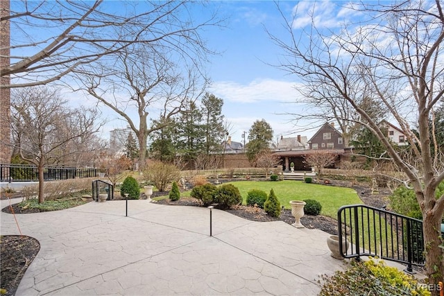 view of home's community featuring a patio area, a lawn, and fence