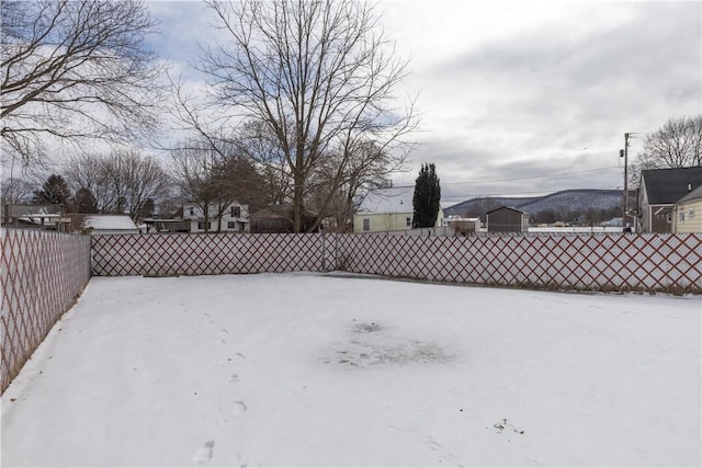 snowy yard featuring fence