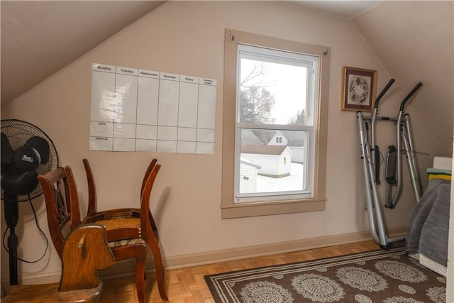 interior space with lofted ceiling, parquet floors, and baseboards