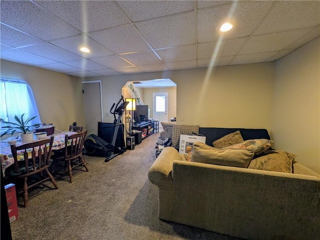 living area featuring a paneled ceiling and carpet flooring