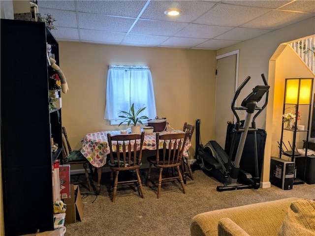 dining area featuring a drop ceiling and carpet flooring