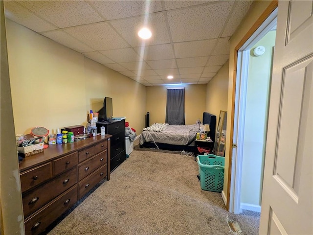 bedroom featuring baseboards, a drop ceiling, and carpet flooring