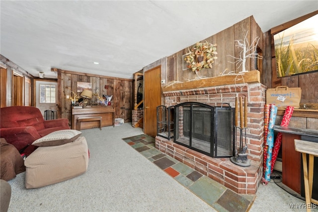 living room with a baseboard heating unit, dark colored carpet, a brick fireplace, and wood walls