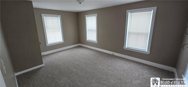 carpeted empty room with baseboards