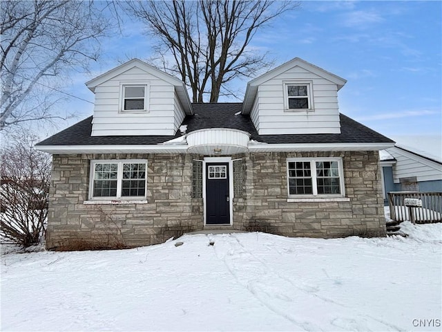 view of front facade featuring stone siding and roof with shingles