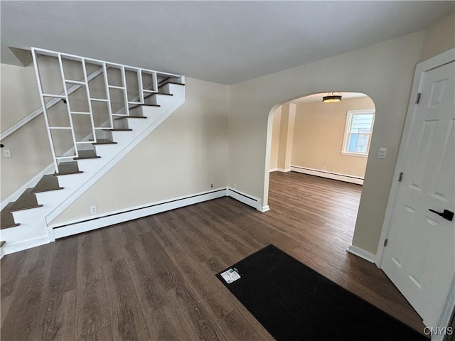 foyer entrance featuring arched walkways, stairway, a baseboard radiator, and dark wood-style floors